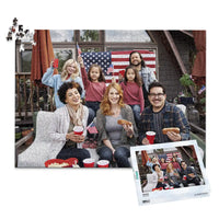 1000 piece 4th of July photo puzzle featuring a family celebrating with American flags and hot dogs, shown with its matching puzzle box
