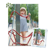 1000 piece personalized puzzle for kids showing a smiling young girl climbing playground ropes, displayed with the matching puzzle box.