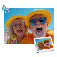 1000 piece personalized couple puzzle featuring a joyful older couple wearing sun hats at the beach, shown with its matching puzzle box