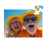 100 piece personalized couple puzzle featuring a joyful older couple wearing sun hats at the beach.