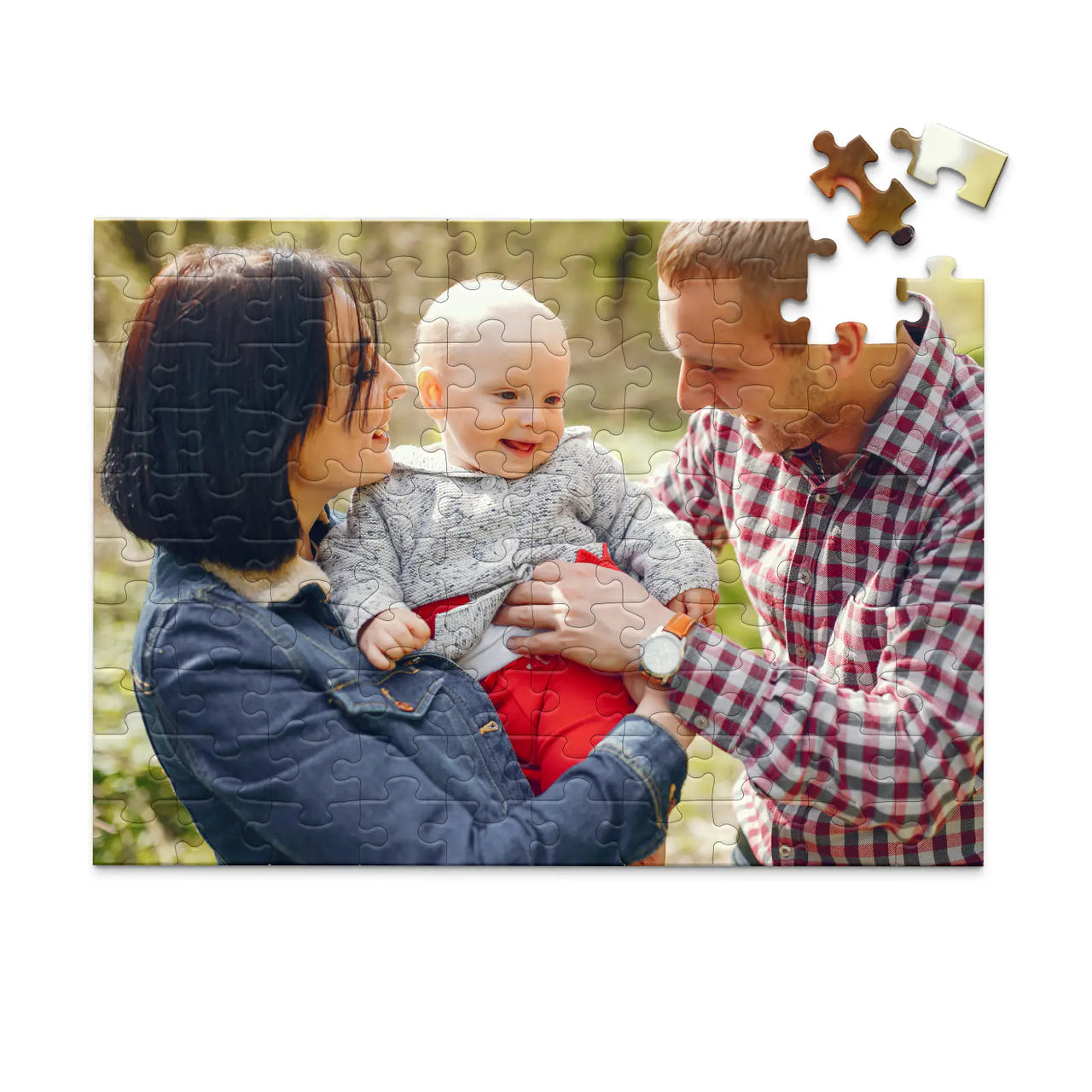 100 piece personalized puzzle for new parents showing a smiling mother and father holding their baby outdoors.