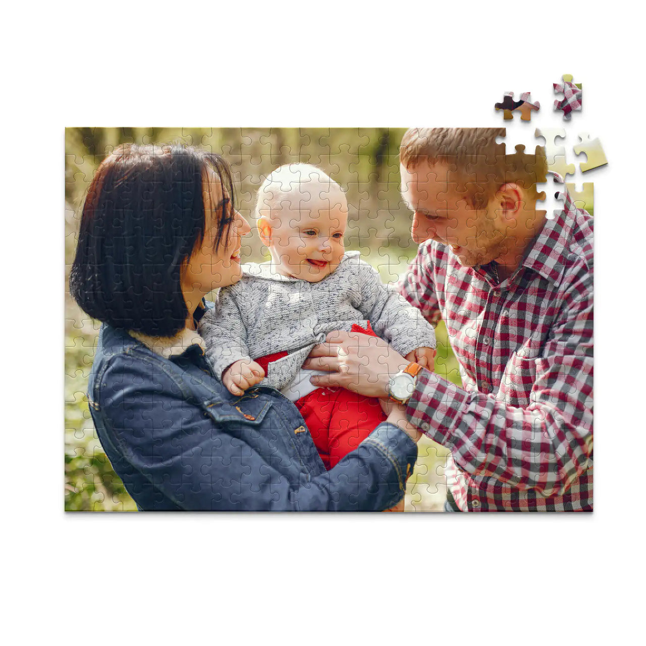 252 piece personalized puzzle for new parents showing a smiling mother and father holding their baby outdoors.