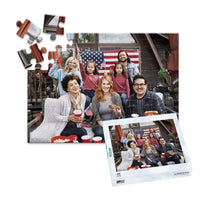48 piece 4th of July photo puzzle featuring a family celebrating with American flags and hot dogs, shown with its matching puzzle box