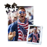 48 piece 4th of July photo puzzle featuring a cheering man wearing an American flag scarf, shown with its matching puzzle box