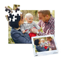 48 piece personalized puzzle for new parents showing a smiling mother and father holding their baby outdoors, displayed with the matching puzzle box.