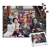 500 piece 4th of July photo puzzle featuring a family celebrating with American flags and hot dogs, shown with its matching puzzle box