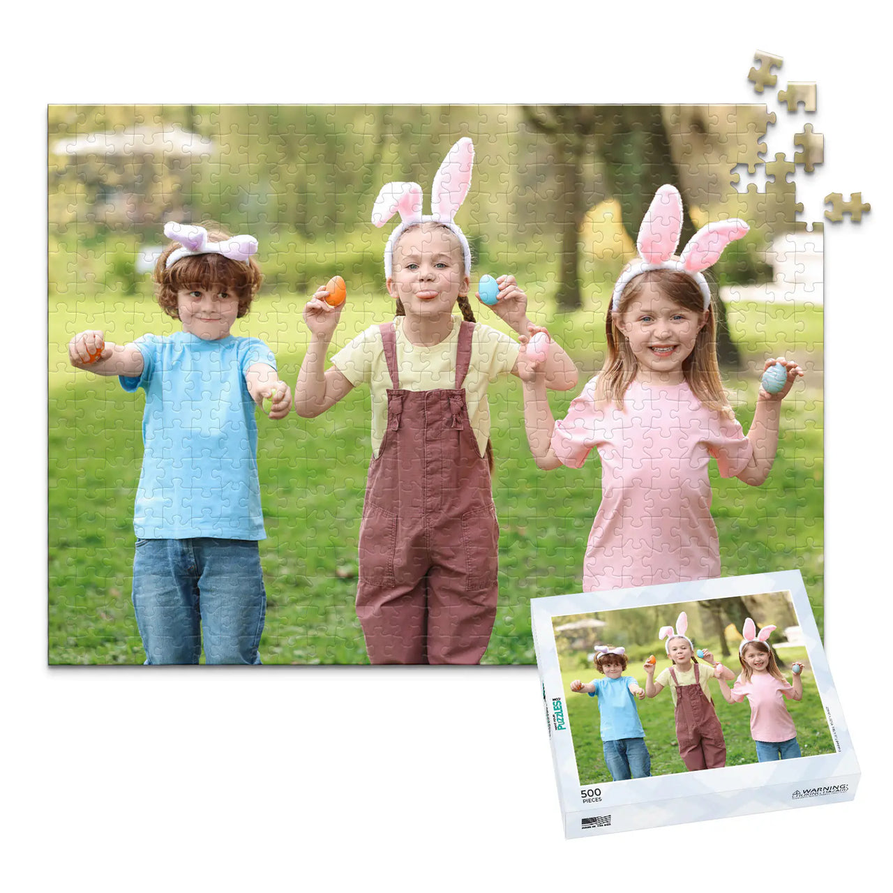 500 piece Easter photo puzzle featuring three children wearing bunny ears and holding colorful Easter eggs, shown with its matching puzzle box
