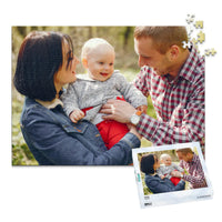 500 piece personalized puzzle for new parents showing a smiling mother and father holding their baby outdoors, displayed with the matching puzzle box.