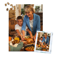500 piece Thanksgiving photo puzzle featuring a grandmother and grandson serving turkey at a family dinner, shown with its matching puzzle box