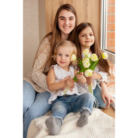 Custom Mother’s Day Puzzle featuring a portrait of a smiling mother and her two daughters holding pale yellow tulips.