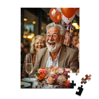 Personalized Birthday Puzzle 100 Pieces featuring a photo of a smiling older man with a white beard and glasses, wearing a brown blazer, seated at a table with balloons, flowers, and a champagne flute.