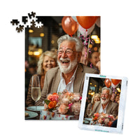 Personalized Birthday Puzzle 252 Pieces with matching puzzle box featuring a photo of a smiling older man with a white beard and glasses, wearing a brown blazer, seated at a table with balloons, flowers, and a champagne flute.