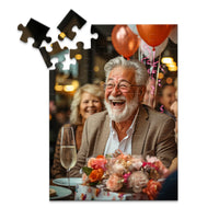Personalized Birthday Puzzle 48 Pieces featuring a photo of a smiling older man with a white beard and glasses, wearing a brown blazer, seated at a table with balloons, flowers, and a champagne flute.