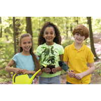Personalized Puzzle for Kids showing three children standing outdoors in a wooded area, each holding gardening tools: a girl on the left holds a bright yellow watering can, the center child holds a small potted plant, and the boy on the right holds a hand trowel. They are smiling and appear to be participating in a gardening or planting activity.