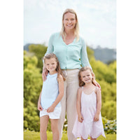 Personalized Mom Puzzle of a young mom standing outdoors with her two young girls in light blue and pale pink sleeveless dresses, wearing a mint green button-front cardigan and beige pants.