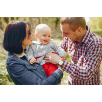 Personalized Puzzle for New Parents showing a family portrait of a mother, father, and baby outdoors. The mother on the left wears a dark blue denim jacket, holding a baby in the center who is wearing a gray knit sweater and red pants.